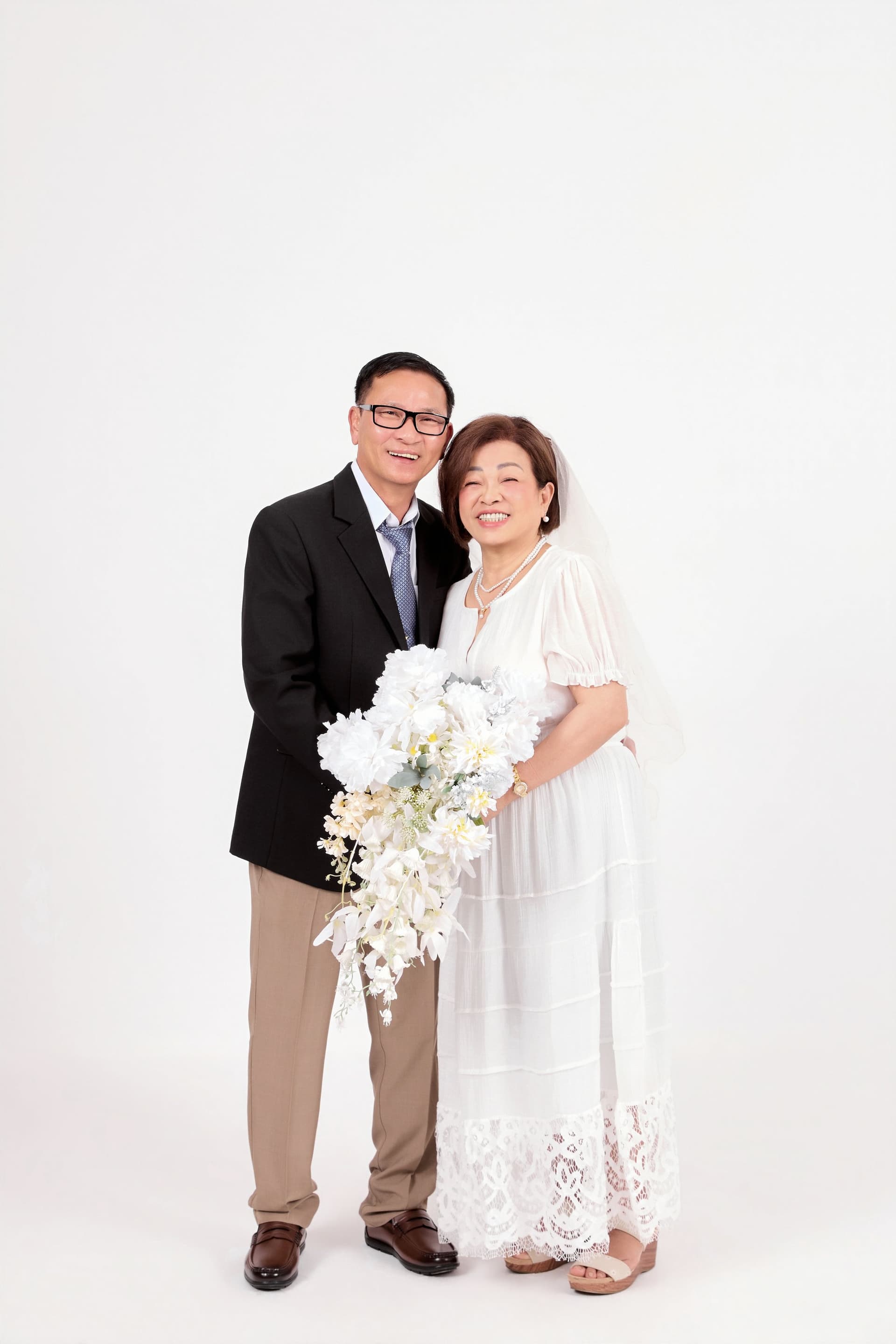 Cặp đôi cô dâu chú rể trẻ trung đứng sát bên nhau mỉm cười đầy mong đợi và hạnh phúc