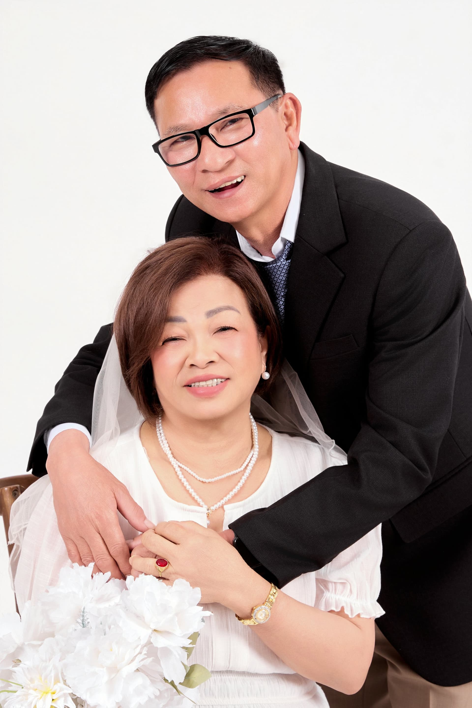 Bố mẹ lớn tuổi ngồi tựa sát bên nhau cười hiền hậu, ánh mắt ngập tràn hạnh phúc