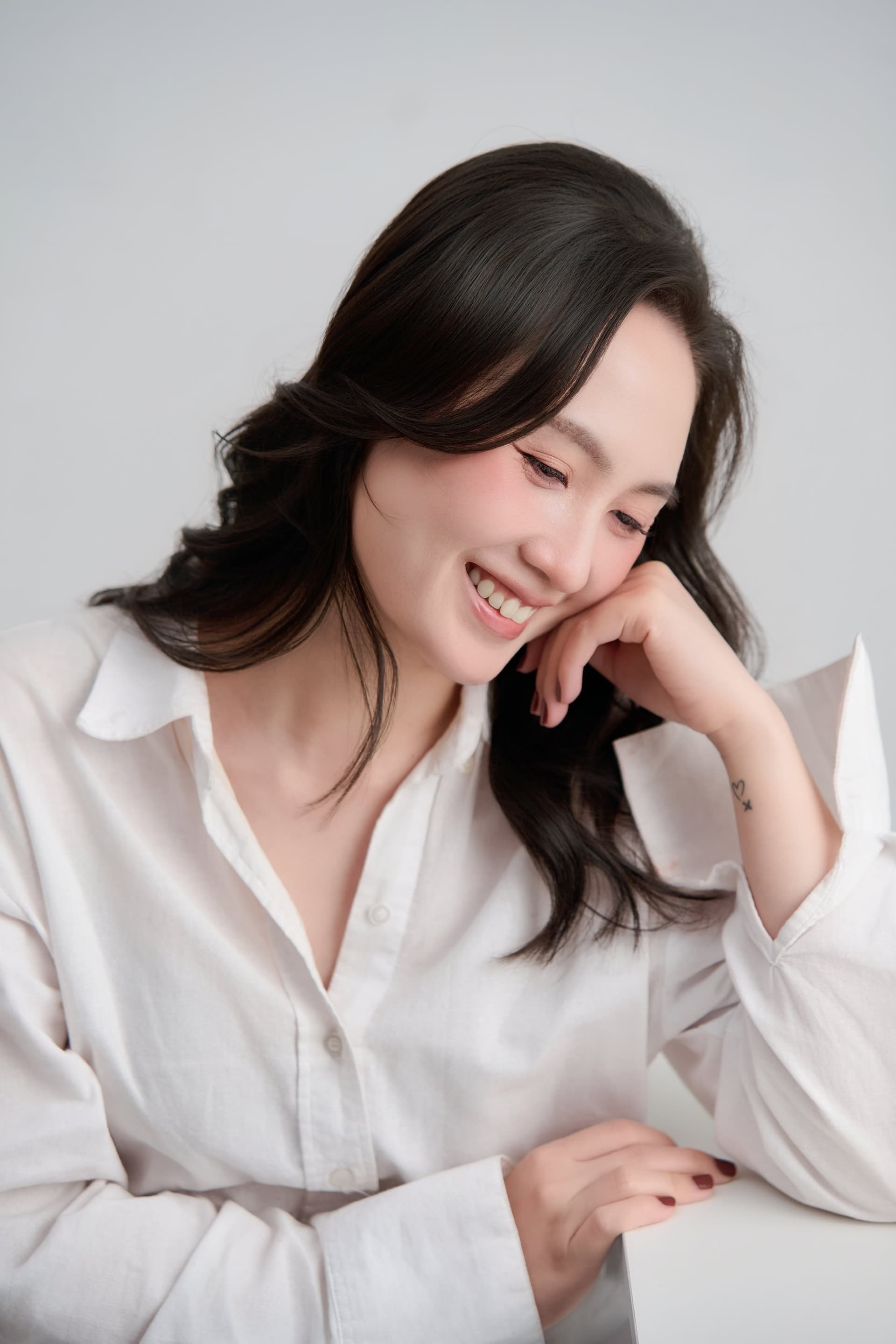 Chân dung Phương với nụ cười dịu dàng, nghiêng mặt sang bên đầy suy tư và tĩnh lặng.