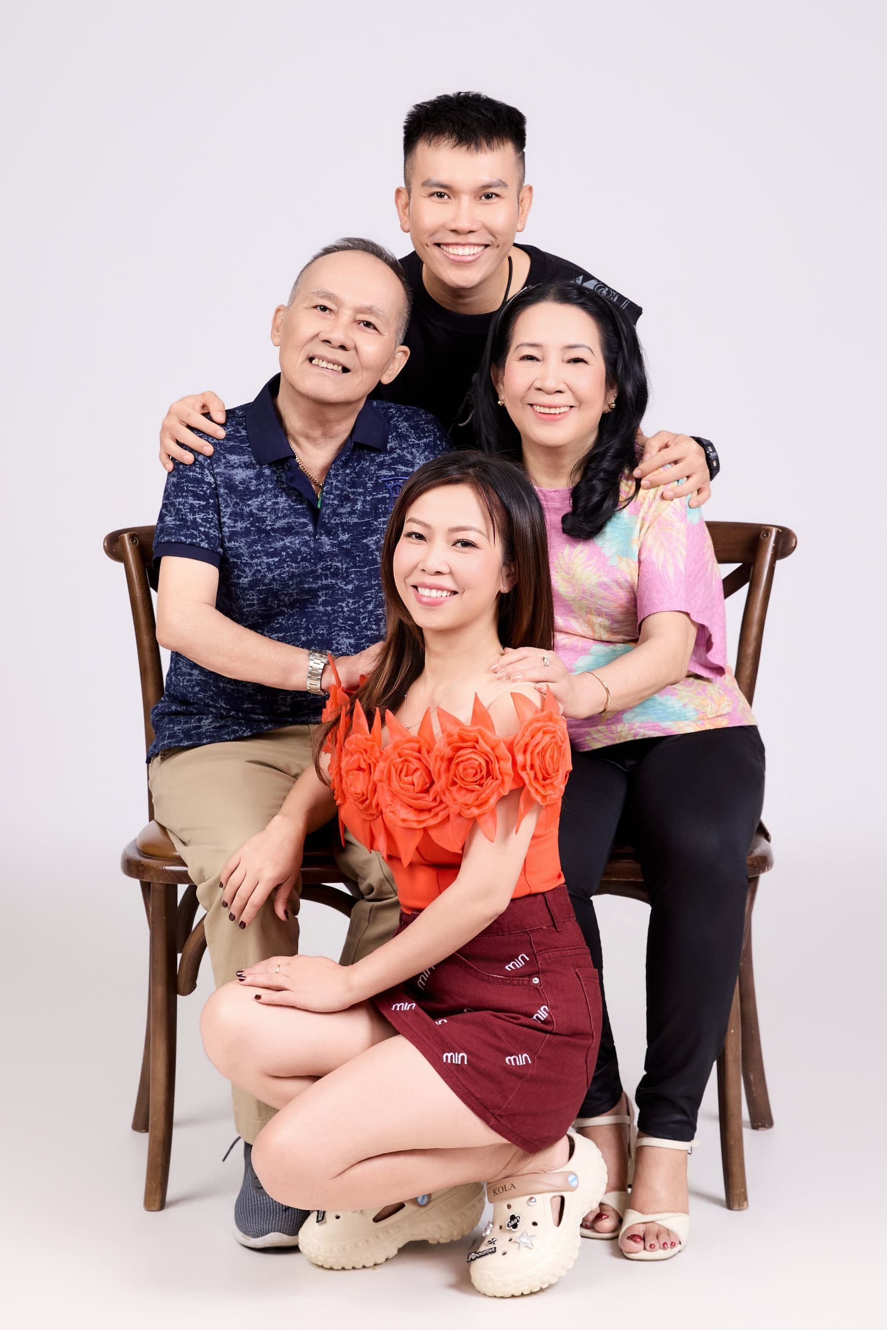 Cả nhà bốn người ngồi cạnh nhau trên ghế gỗ, người tựa người — một mái nhà có người đi xa đã về, có một ngày cùng nhau