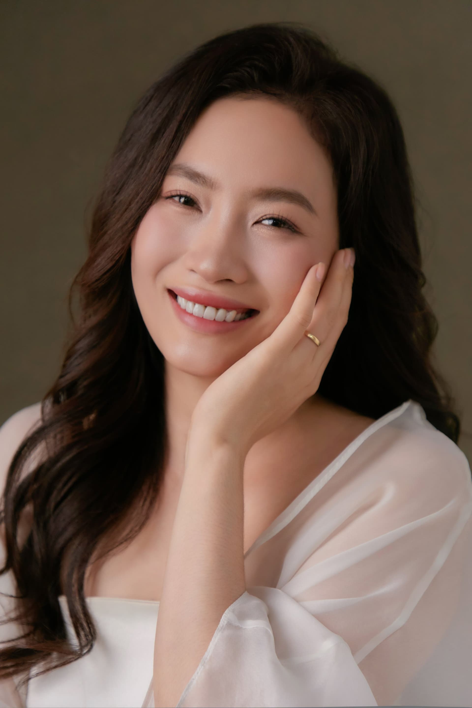 Lan Hương ôm bó hoa pastel, gương mặt cười nhẹ trong ánh sáng dịu của một ngày Sài Gòn