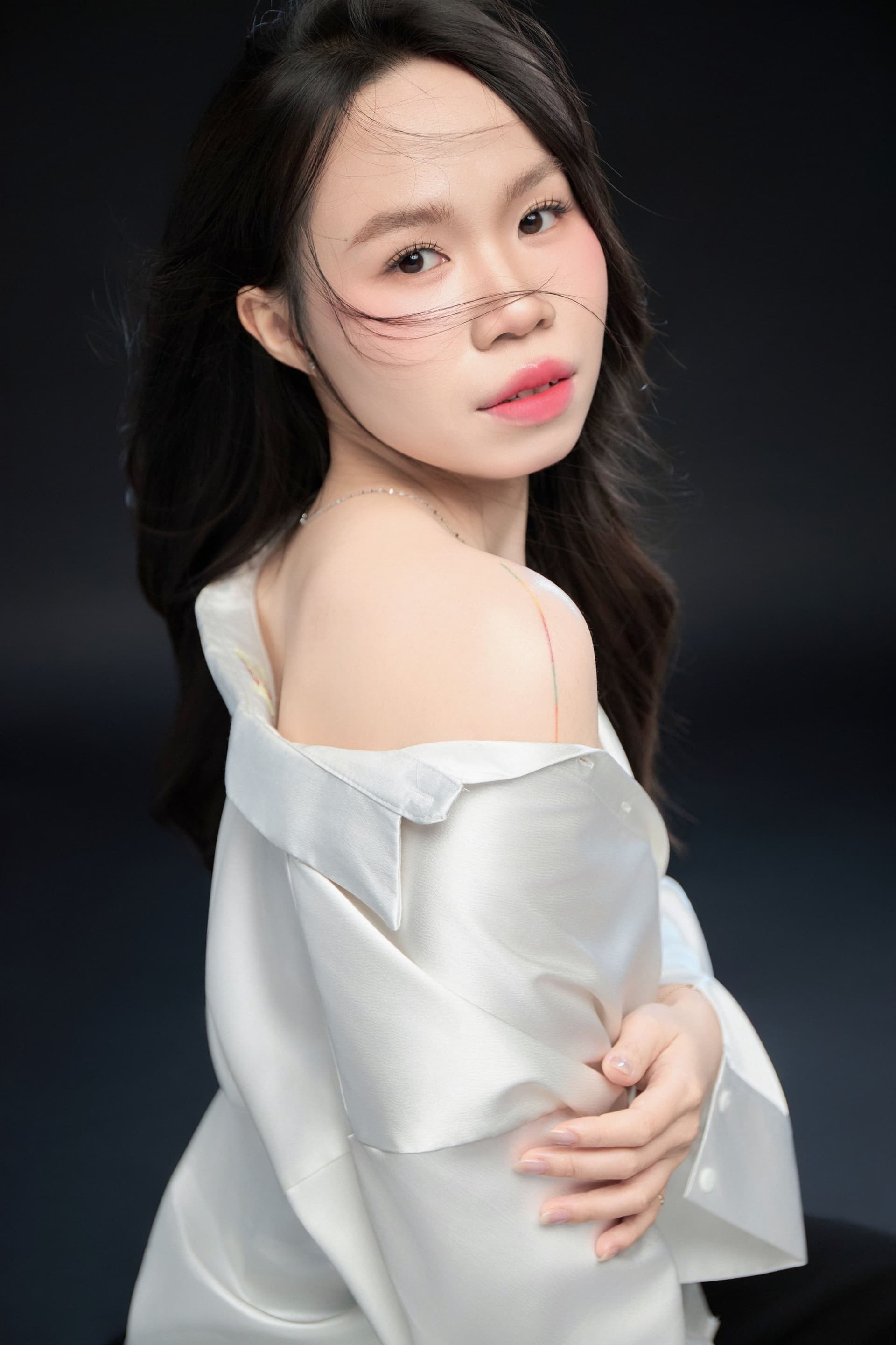 Chân dung nghiêng cô gái áo trắng, ánh sáng nhẹ trên gương mặt — vẻ trầm của tuổi đôi mươi giữa những mâu thuẫn rất riêng