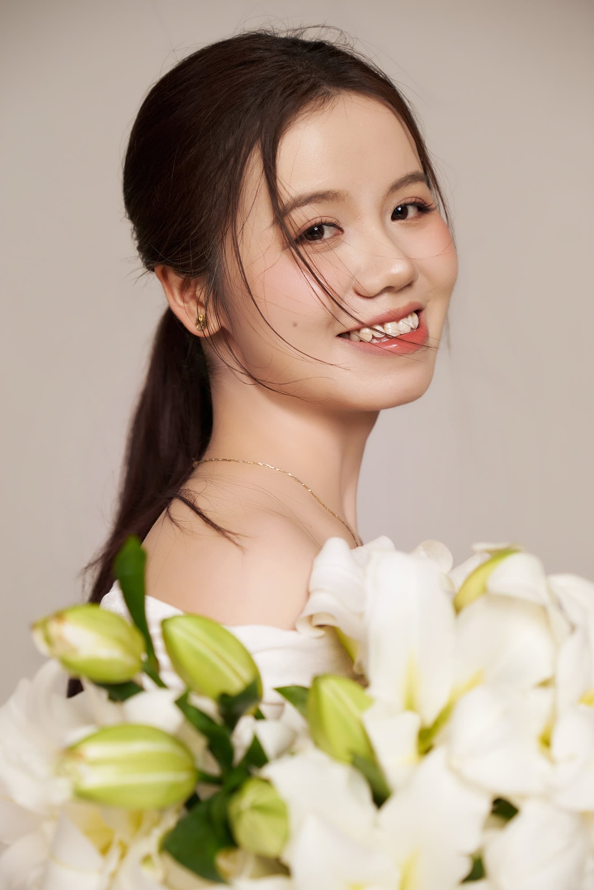 Doãn Hường cười tươi tắn trong tà áo dài lụa màu mỡ gà quý phái, gợi cảm giác dịu dàng ấm áp