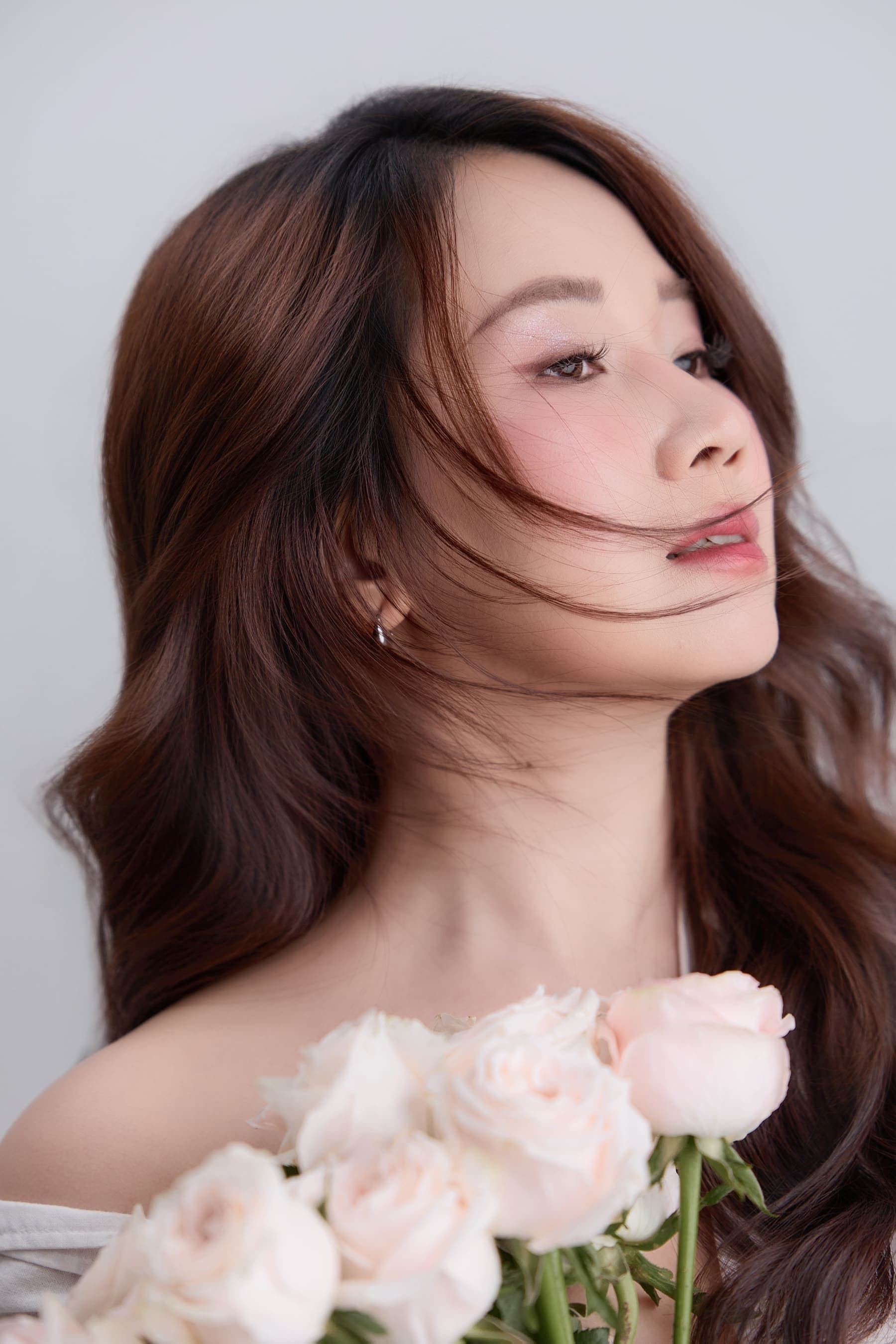 Người phụ nữ tuổi bốn mươi ôm hoa, ánh nhìn mềm sau những phân vân rất đàn bà