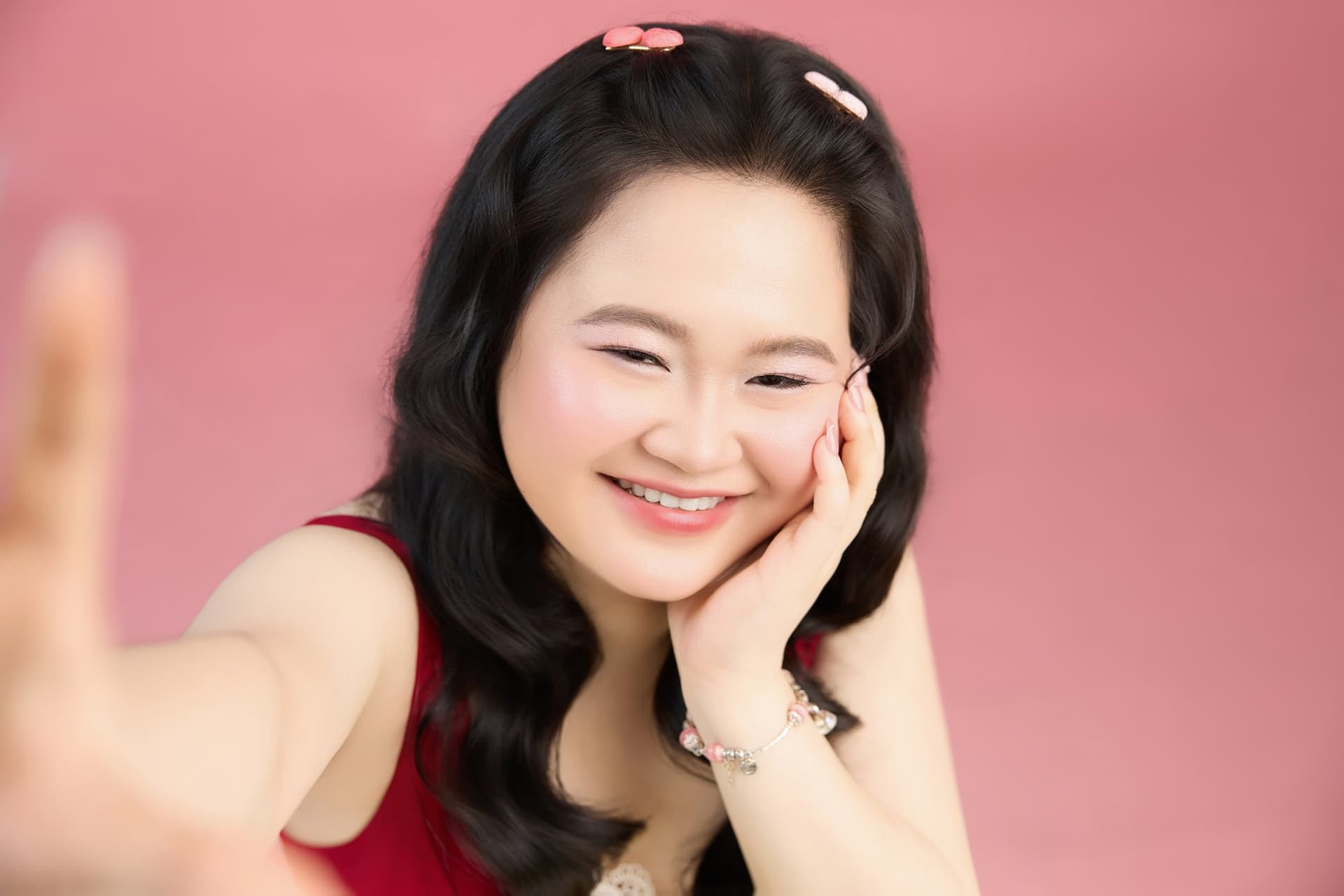 Phương nở nụ cười rạng rỡ khi tựa cằm trên tay đầy thư thái trong tà áo đỏ ấm áp