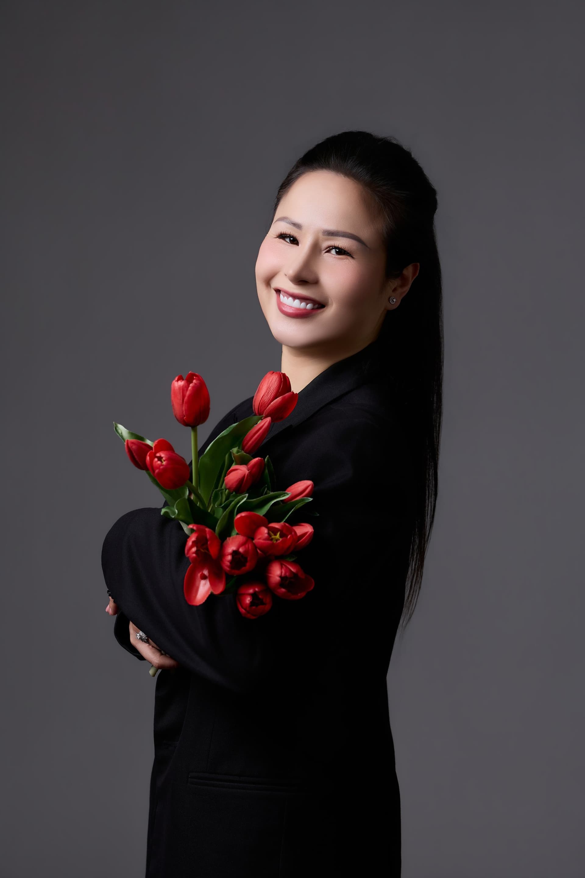 Người phụ nữ áo sơ mi trắng, mỉm cười dịu — gương mặt của một người làm nghề tử tế, đi qua từng việc nhỏ mỗi ngày