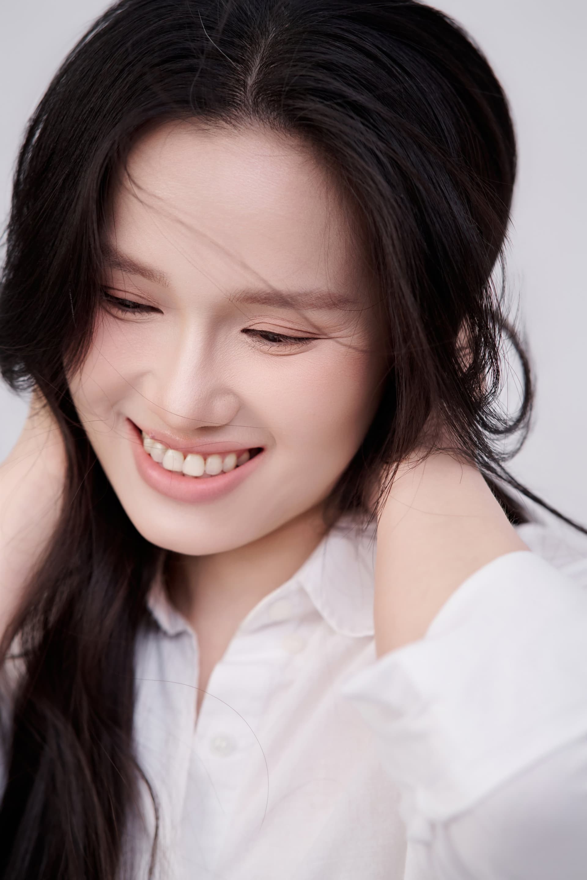 Chân dung chị Khánh Huyền cười rạng rỡ, hai bàn tay đỡ cằm trên nền trắng dịu dàng.