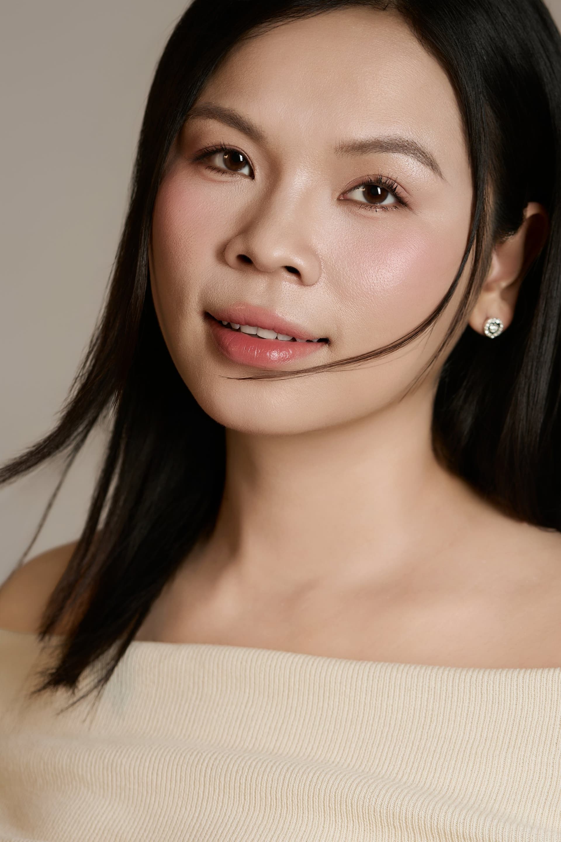 Chị Lâm Trang mặc áo trễ vai màu kem dịu nhẹ nở nụ cười hiền hậu, ánh mắt rạng rỡ hạnh phúc