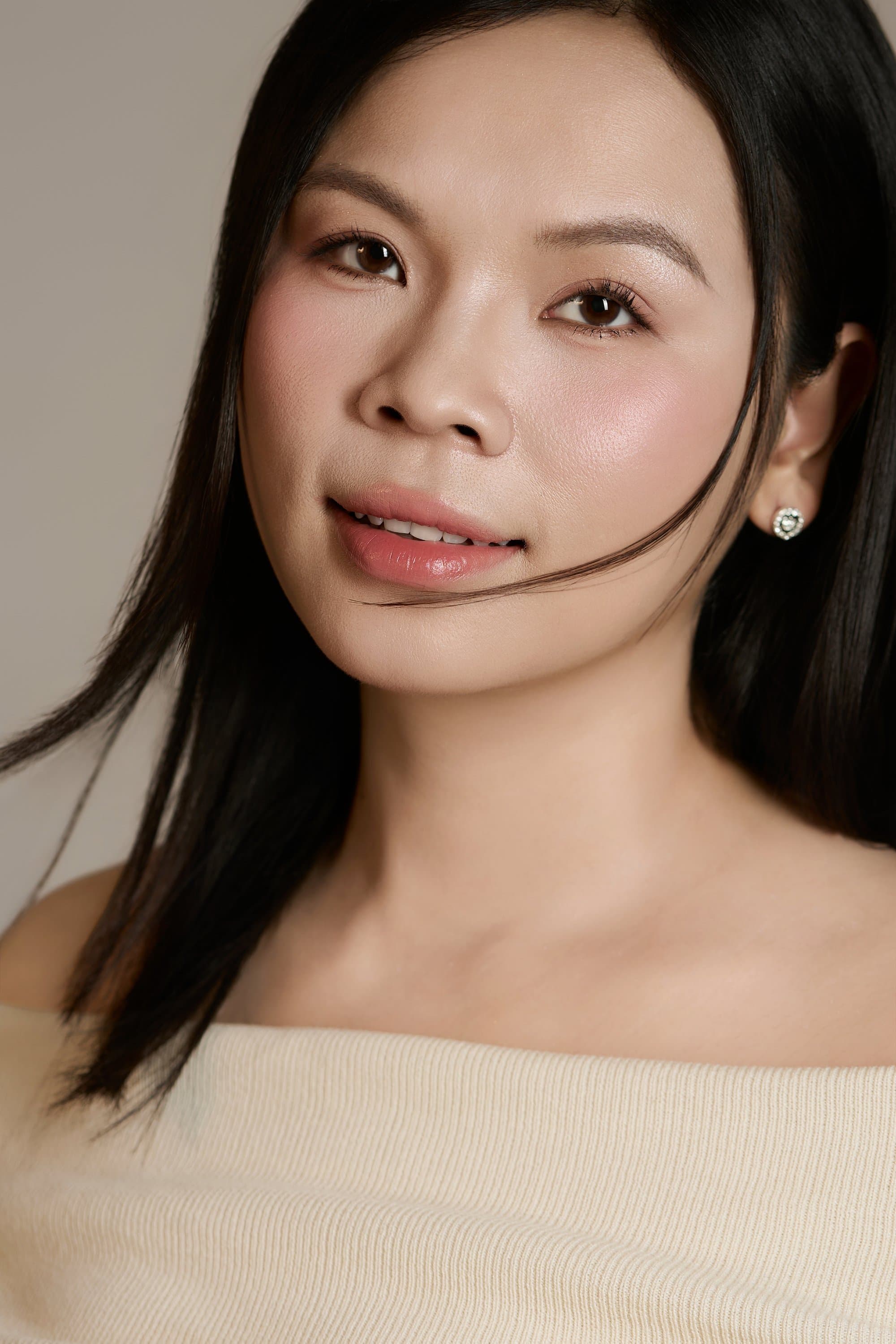 Chị Lâm Trang mặc áo trễ vai màu kem dịu nhẹ nở nụ cười hiền hậu, ánh mắt rạng rỡ hạnh phúc