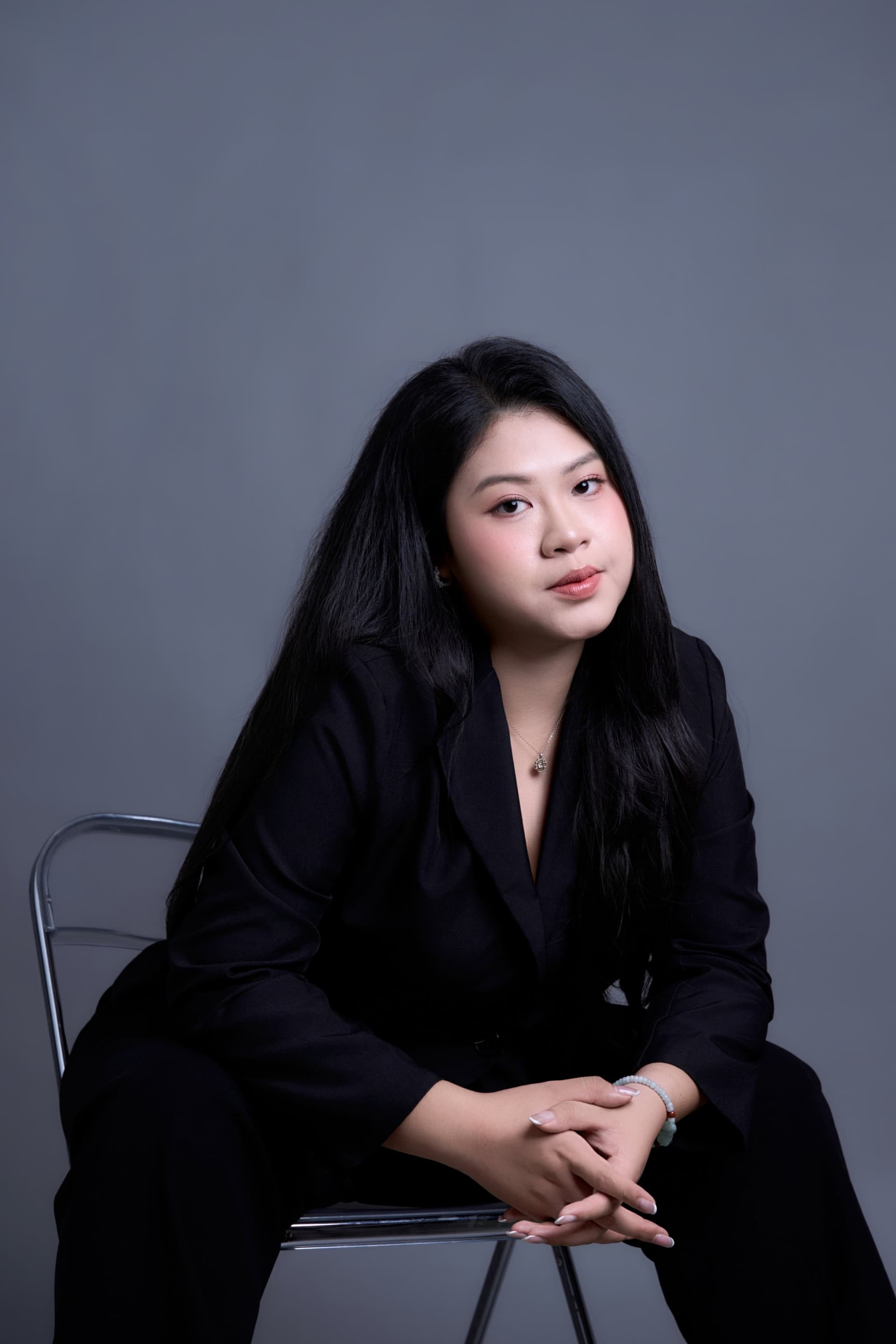 Người phụ nữ ngồi yên, áo đen, gương mặt lặng — ghi nhận chính mình trước khi bước sang một vai mới