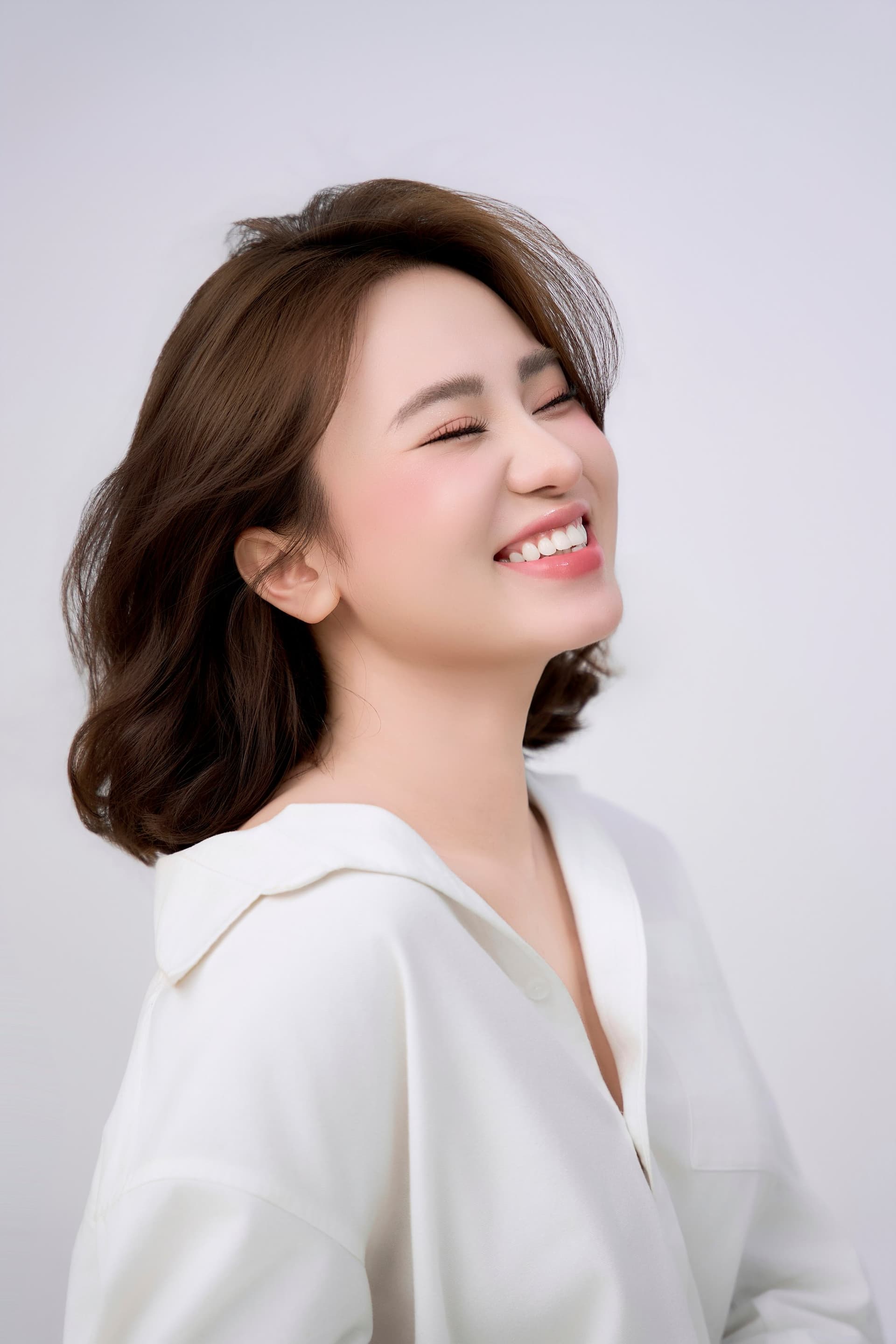 Người phụ nữ áo trắng, chân dung dịu, ánh nhìn điềm tĩnh