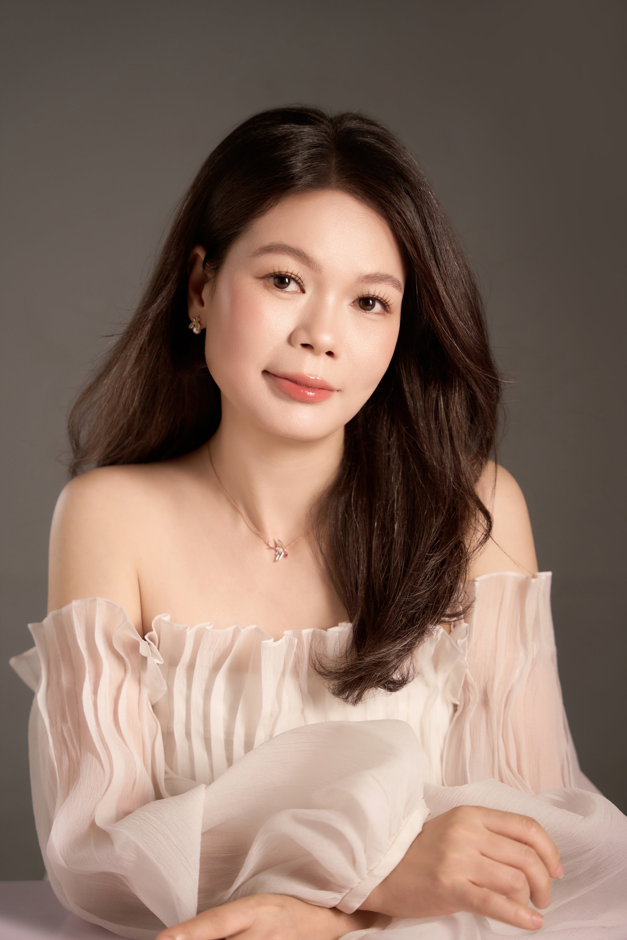 Vũ Huệ ánh nhìn dịu, vai trần áo nhẹ tone hồng phấn — chân dung mở đầu một ngày sinh nhật rất riêng của người phụ nữ đã có gia đình
