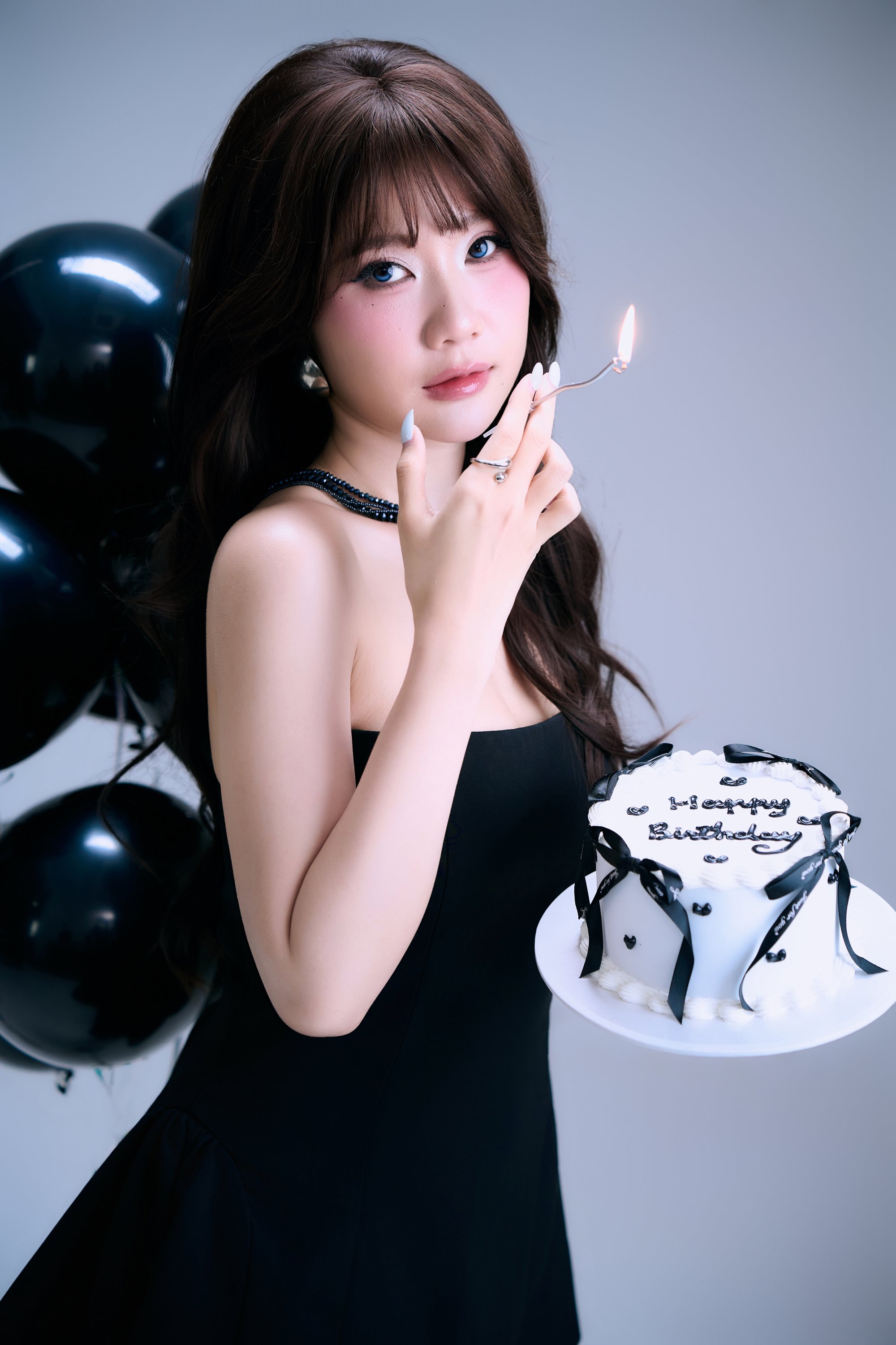 Phương ngồi giữa balloon đen — váy đen, ánh nhìn lặng