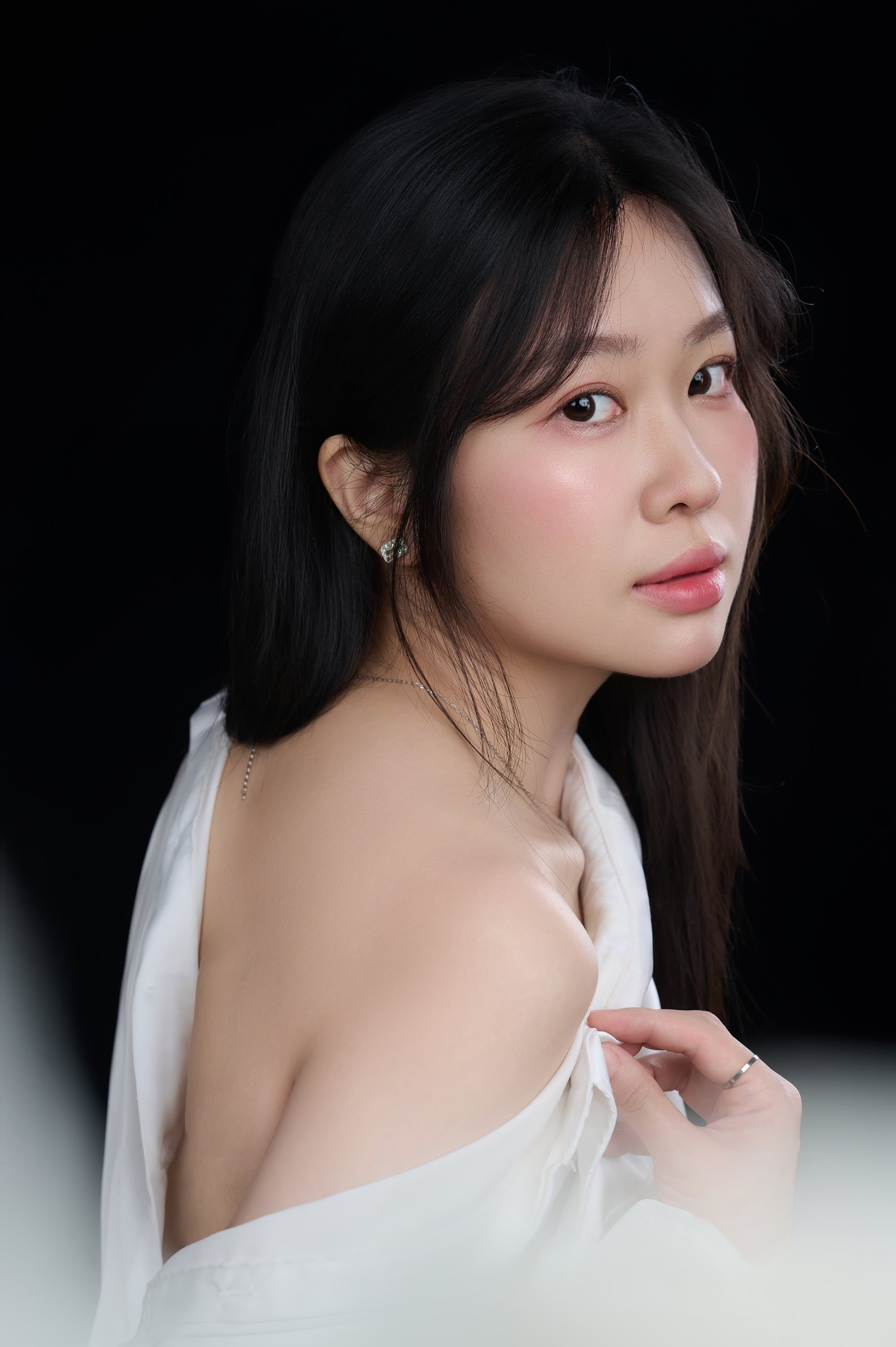 Chân dung nghiêng, người phụ nữ áo trắng, gương mặt sáng tự nhiên — sự dịu dàng còn nguyên giữa đời sống bận