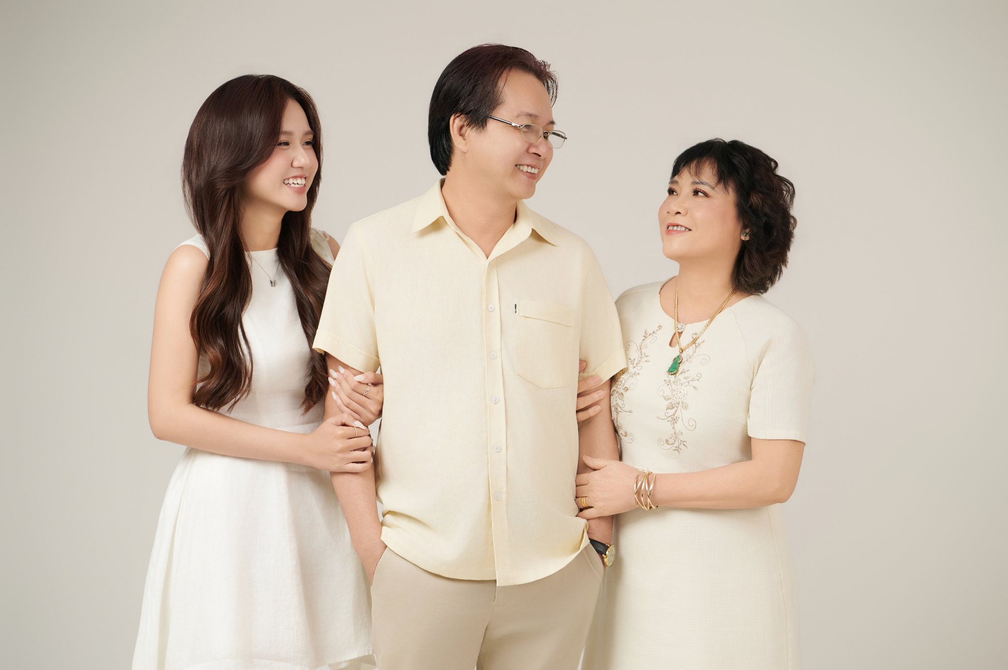 Cận cảnh người đàn ông trung niên đeo đồng hồ dây da đen ở cổ tay, tay đặt trên vai con gái — cử động đã quen từ những năm con vào cấp ba