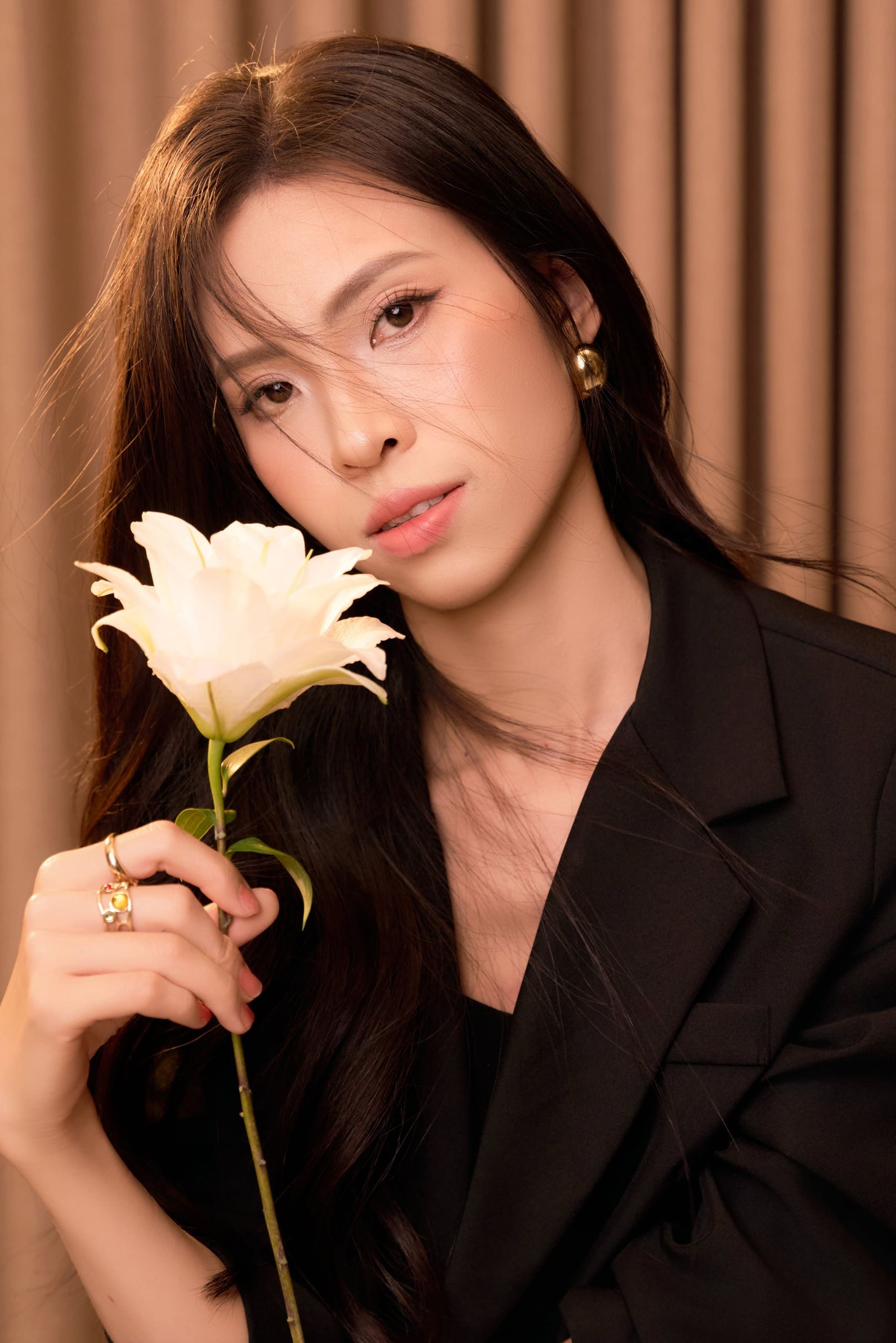 Chị Hồng Tươi ngồi tựa nhẹ, cầm cánh hoa lily trắng — một phần để dành rất lâu, đã được nhô lên