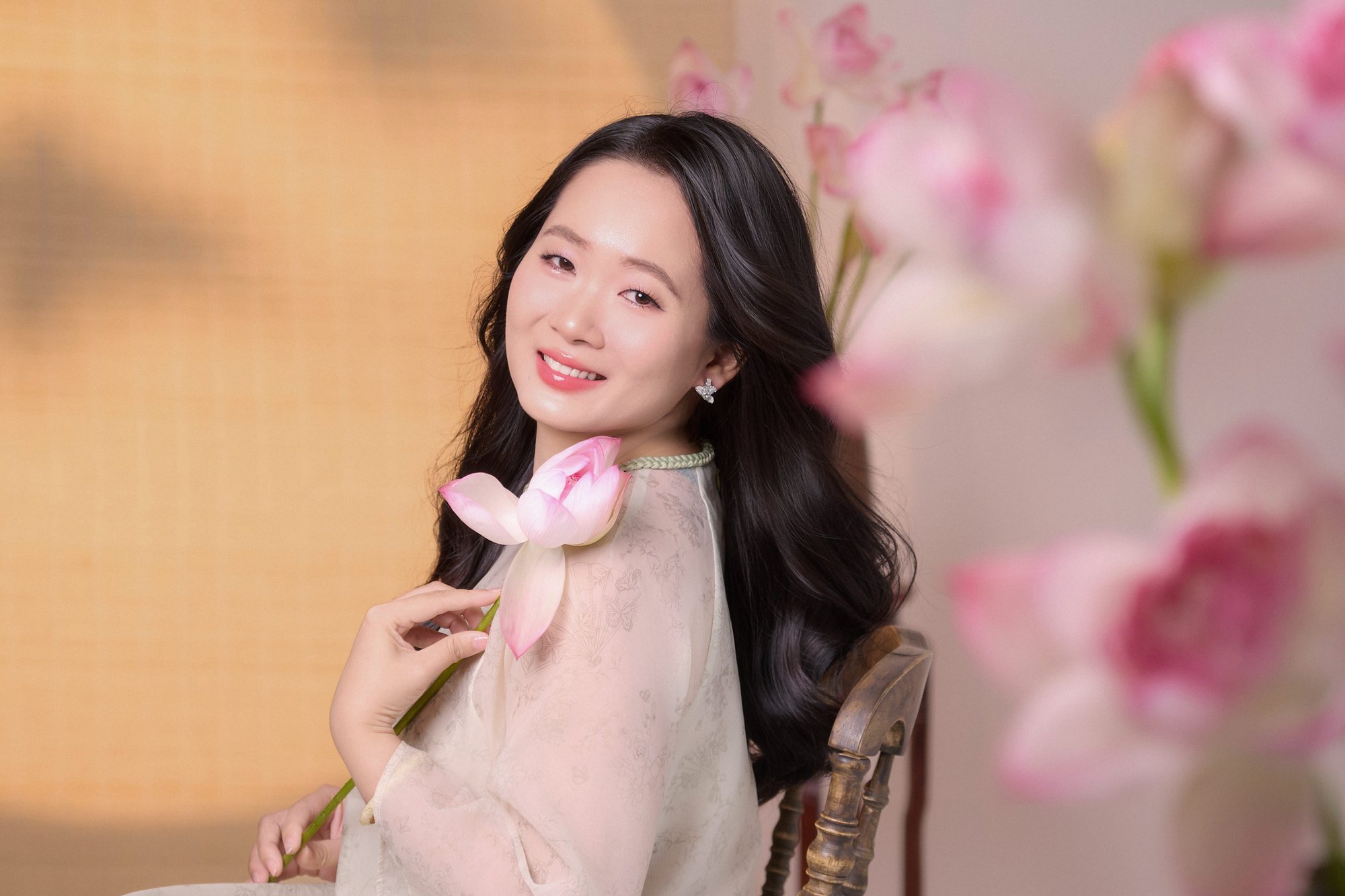 Người phụ nữ áo trắng cầm hoa sen, dáng thanh thoát, mood nở ra dịu dàng
