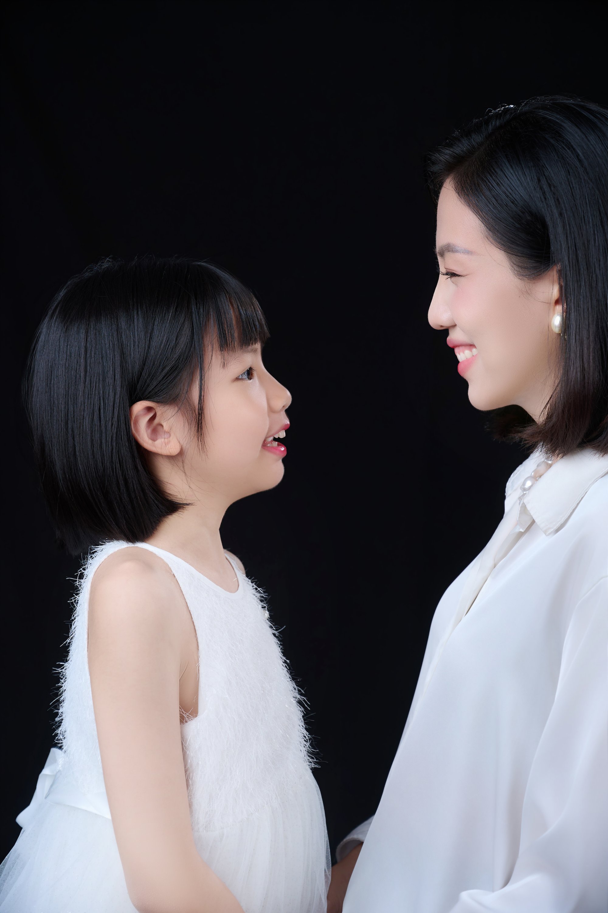Người mẹ đứng cạnh con gái nhỏ, cả hai mặc áo trắng, ánh nhìn ấm — phần lớn thời gian của chị nằm trong gia đình